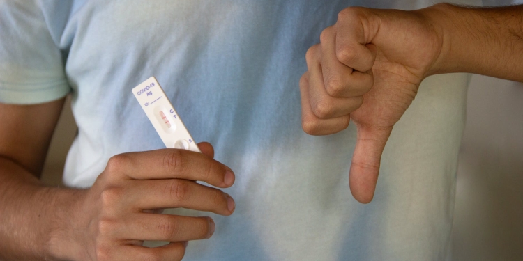 a person holding an antigen rapid test result