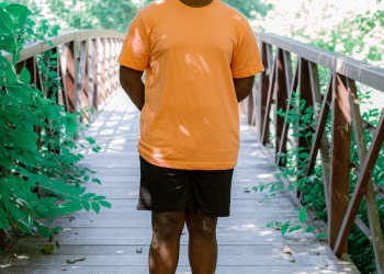 a boy standing on footbridge