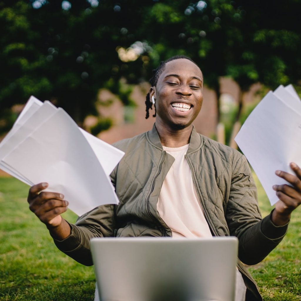 student with documents and laptop happy about getting into university
