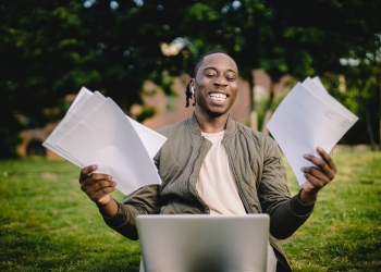 student with documents and laptop happy about getting into university