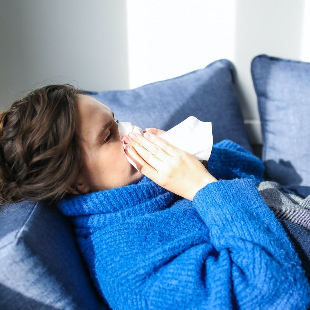 woman in blue sweater lying on bed