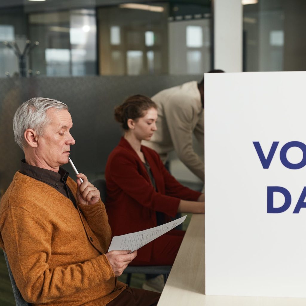 a man reading his vote ballot