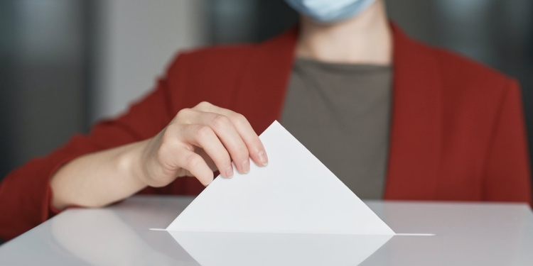 ballot box with person casting a vote
