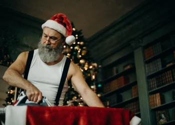 man in white tank top ironing red top