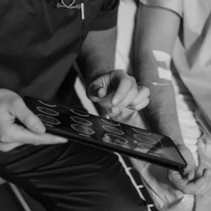 grayscale photo of a doctor holding a digital tablet