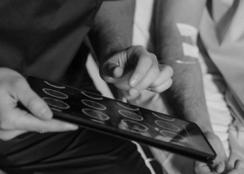 grayscale photo of a doctor holding a digital tablet