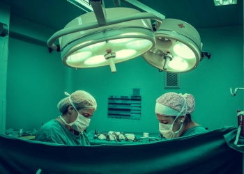 two person doing surgery inside room