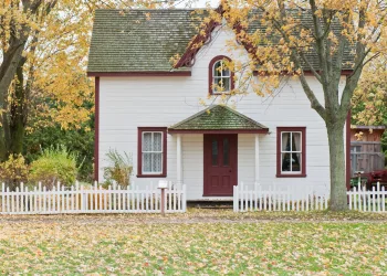 white and red wooden house with fence