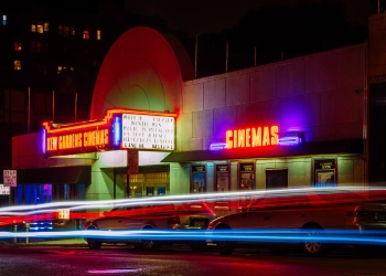 time lapse photography of car lights in front of cinema