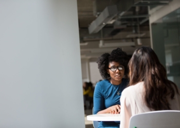 woman wearing blue top beside table