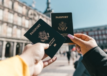 anonymous tourists showing us passports on street on sunny day