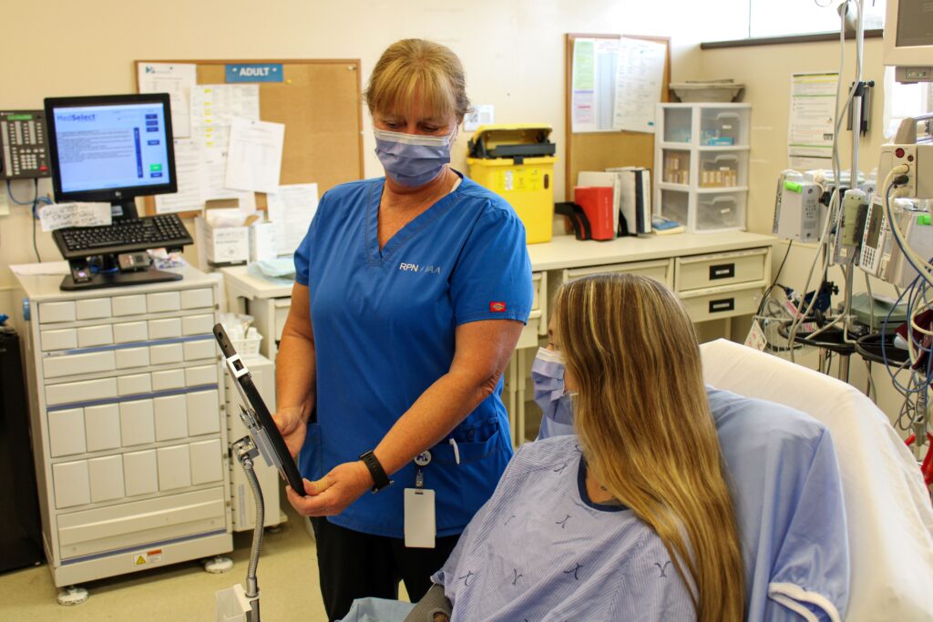 Emergency Department Nurse Using the Voyce App on a Hospital Tablet