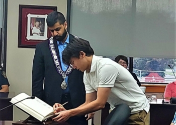 the Mayor and Maxwell Hum signing the Book of Recognition.