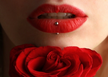 woman wearing red lipstick near red rose
