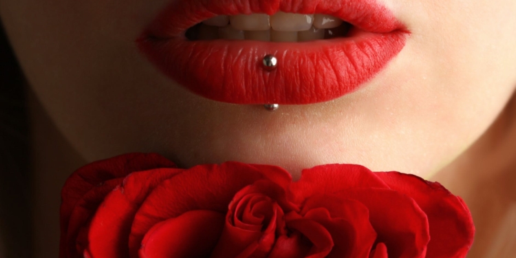 woman wearing red lipstick near red rose