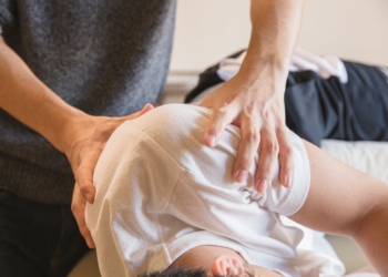 male doctor massaging shoulders of patient