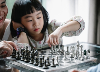 pensive asian girl playing chess