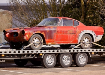 red coupe on flatbed trailer