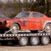 red coupe on flatbed trailer