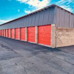a storage building with red doors and a sky background