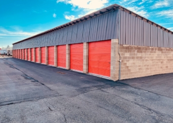 a storage building with red doors and a sky background