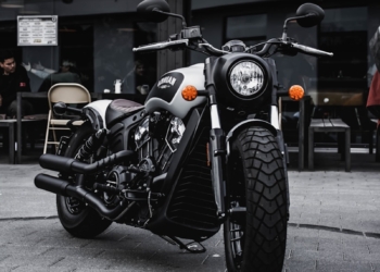 black and gray cruiser motorcycle parked beside black concrete building