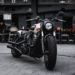 black and gray cruiser motorcycle parked beside black concrete building