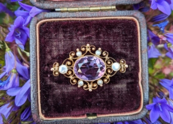 gold and silver round analog watch on black and purple case