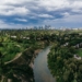 aerial view of city buildings and trees under cloudy sky during daytime
