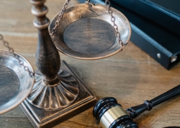 From above of judicial symbols consisting of Scales of Justice and small judge hammer with curly handle