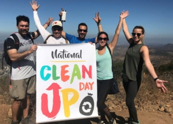 man in white crew neck t-shirt holding white and blue poster