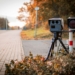black and gray camera on tripod on road during daytime