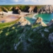 rocky hill with grass facing ocean