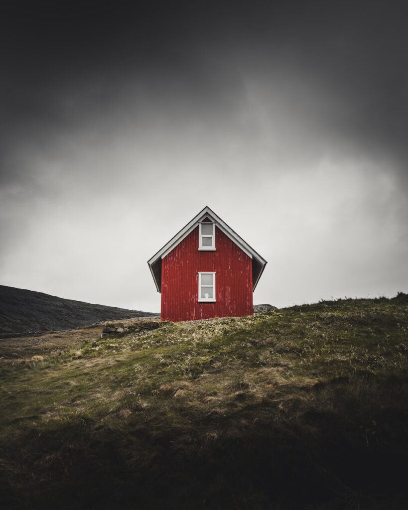 photo of red barn house on top of hill