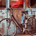 black and gray cruiser bicycle in front of blue wooden door
