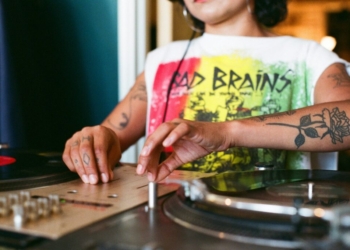 a woman is playing a record on a turntable