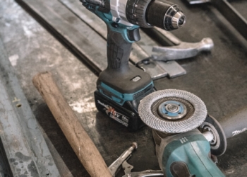 green Makita cordless drill near angle grinder
