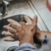 person in white shirt washing hands