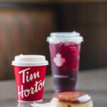 a cup of coffee and a doughnut on a table