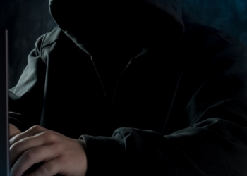 a man in a hoodie using a laptop computer