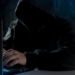a man in a hoodie using a laptop computer