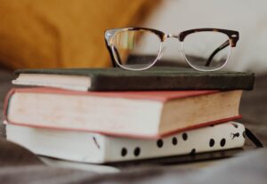 club master eyeglasses on pile of three books