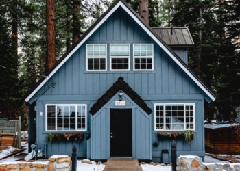 white and brown wooden house near green trees during daytime