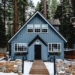 white and brown wooden house near green trees during daytime
