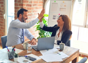 man in white dress shirt sitting beside woman in black long sleeve shirt