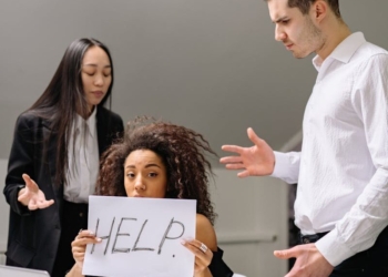Woman in Black Shirt Holding White Paper with Text
