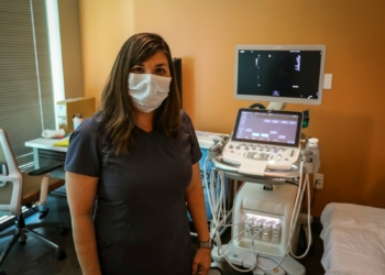 woman in black crew neck t-shirt standing near black flat screen tv