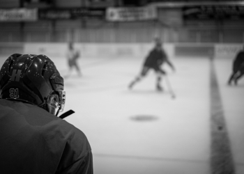 a group of people playing a game of ice hockey