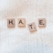 the word hate spelled with scrabbled wood blocks