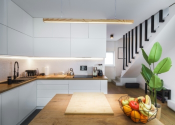 A kitchen with a wooden counter top next to a plant